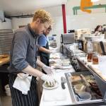 Cooper Golding assembles a Rob’s Favorite crumpet with green egg, English cheese, tomato on smoked salmon cream cheese on Tuesday, June 24, 2025 in Edmonds, Washington. (Olivia Vanni / The Herald)