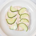 Cucumbers cover smoked salmon cream cheese on a crumpet on Tuesday, June 24, 2025 in Edmonds, Washington. (Olivia Vanni / The Herald)