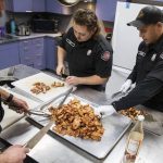 Everett firefighters chop up chicken for stir-fry. (Olivia Vanni / The Herald)
Everett firefighters chop up chicken for stir-fry. (Olivia Vanni / The Herald)