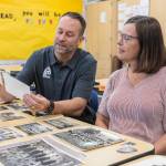 North Middle School Principal Tyler Ream and teacher Jenny Overstreet look through historic photographs of North Middle School on Tuesday, Sept. 9, 2025 in Everett, Washington. (Olivia Vanni / The Herald)