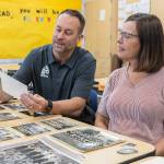 North Middle School Principal Tyler Ream and teacher Jenny Overstreet look through historic photographs of North Middle School on Tuesday, Sept. 9, 2025 in Everett, Washington. (Olivia Vanni / The Herald)