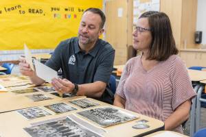 North Middle School Principal Tyler Ream and teacher Jenny Overstreet look through historic photographs of North Middle School on Tuesday, Sept. 9, 2025 in Everett, Washington. (Olivia Vanni / The Herald)