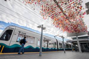 A person walks past Laura Haddads Cloud sculpture before boarding a Link car on Monday, Oct. 14, 2024 in SeaTac, Washington. (Olivia Vanni / The Herald)