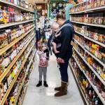 Elizabeth Ferrari hands her mom Noelle Ferrari her choice of hot sauce from the large selection at Double DD Meats on in January 2023 in Mountlake Terrace. (Olivia Vanni / The Herald file photo)