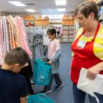 Aleen Alshamman (center) carries a basket as she picks out school clothes with the help of an Operation School Bell volunteer on Sept. 24 in Everett. Operation School Bell is an Assitance League of Everett program. (Olivia Vanni / The Herald file photo)