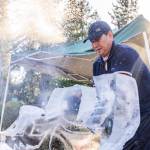 Ice and water spray as Chan Kitburi begins to carve out pieces of ice on his sculpture outside of his home on Sept. 17, 2025 in Marysville, Washington. (Olivia Vanni / The Herald)