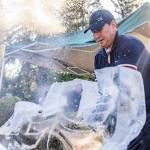 Ice and water spray as Chan Kitburi begins to carve out pieces of ice on his sculpture outside of his home on Sept. 17, 2025 in Marysville, Washington. (Olivia Vanni / The Herald)