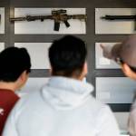 Customers look at assault-style rifles on a mostly empty display wall at Rainier Arms, April 14, 2023, in Auburn, as stock dwindles before a state law banning the firearms sale took effect. (Lindsey Wasson / Associated Press file photo)