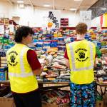 Shane Martinez, 16, left, works with Caison Robinson, 17, to organize food during the Cascade High School food drive event on Wednesday, Dec. 17, 2025, in Everett, Washington. (Will Geschke / The Herald)