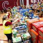 Finley Mikesell, 17, front, works with students to organize food in Cascade High School during its annual food drive event on Wednesday, Dec. 17, 2025, in Everett, Washington. (Will Geschke / The Herald)