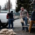 Local residents load sandbags into a truck amid flooding in Mount Vernon on Thursday. Days of heavy rain pushed waterways to record flood levels in a mountainous region north of Seattle. (Grant Hindsley/The New York Times)
