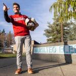 Brandon Tepley, a Washington State University Butch T. Cougar mascot from 1997 to 1999 , does a signature Butch pose while holding a vintage costume head at Mukilteo Elementary, where he is the dean of students. (Olivia Vanni / The Herald)