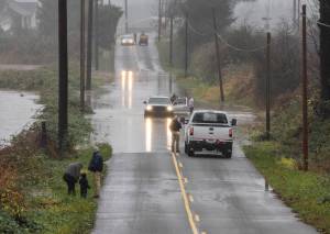 People try to navigate their cars along a flooded road near US 2 on Wednesday, Dec. 10, 2025, in Sultan, Washington. (Olivia Vanni / The Herald)