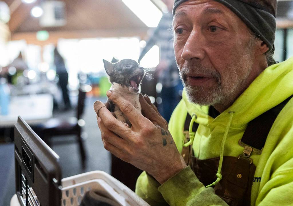 Kevin Stevens holds his Chihuahua puppy inside the Disaster Assistance Center on Wednesday, Jan. 14, 2026 in Sultan, Washington. (Olivia Vanni / The Herald)