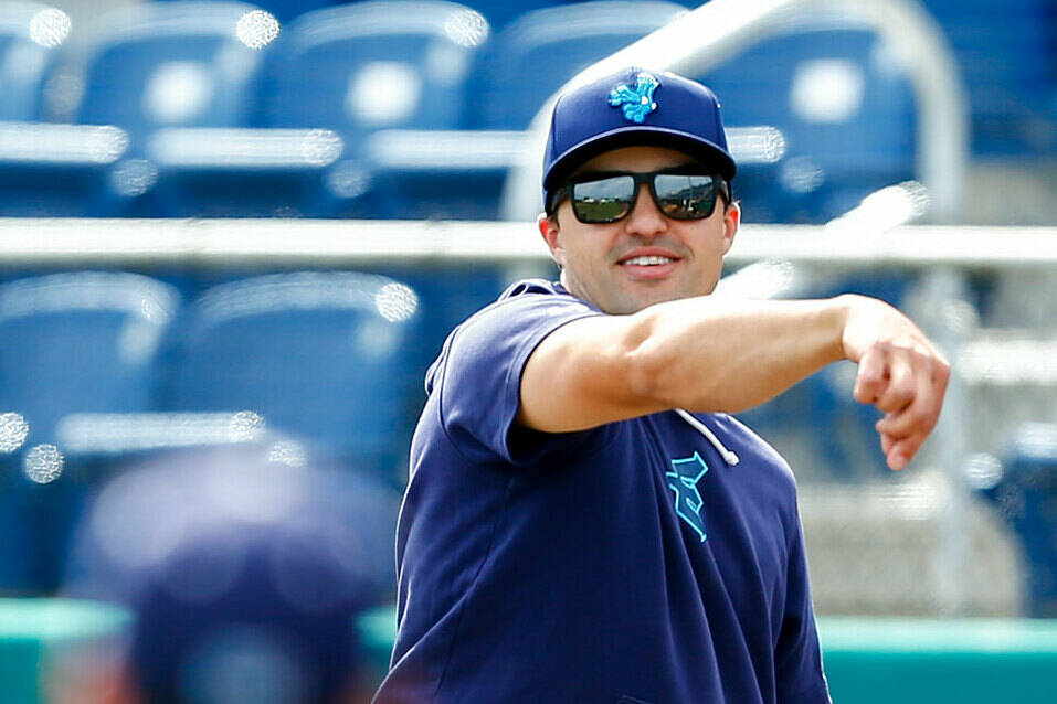 Everett AquaSox manager Ryan Scott plays catch behind the batting cage during practice Tuesday, April 2, 2024, at Funko Field in Everett, Washington. (Ryan Berry / The Herald)