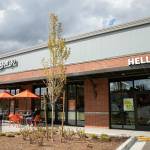 People sit outside the recently opened Amazon Go facility Wednesday, April 27, 2022, in Mill Creek, Washington. (Ryan Berry / The Herald)