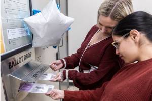 Payton Pavon-Garrido, 23, left, and Laura Castaneda, 28, right, push the ballots into the ballot drop box next to the Snohomish County Auditor’s Office on Tuesday, Nov. 5, 2024 in Everett, Washington. (Olivia Vanni / The Herald)