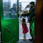Justin “Rook” McIntyre holds open the club house door for Makena Caldwell, 4, during a club gathering on Thursday, March 12, 2026 in Everett, Washington. (Olivia Vanni / The Herald)
