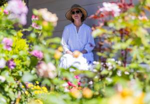 Paula Dickman next to her front yard rose garden on Thursday, Aug. 21, 2025 in Mill Creek, Washington. (Olivia Vanni / The Herald)
