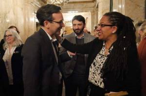 Gov. Bob Ferguson, left, and House Finance Chair April Berg, D-Mill Creek, right, celebrate in the Democratic wings of the House after Democrats bill to impose an income tax on millionaire earners won House approval on March 10, 2026. At center is Shane Esquibel, Ferguson’s chief of staff. (Photo by Bill Lucia/Washington State Standard)