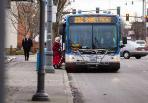 A transit rider steps onto a Community Transit bus on Tuesday, Jan. 3, 2023 in Everett, Washington. (Olivia Vanni / The Herald)