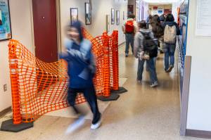 Explorer Middle School students navigate a tight hallway past a recent floor repair that was made due to a leak on Monday, May 11, 2026 in Everett, Washington. (Olivia Vanni / The Herald)