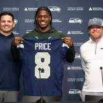 Seahawks first-round pick Jadarian Price holds up his No. 8 jersey during an introductory press conference along with coach Mike Macdonald and general manager John Schneider at the Virginia Mason Athletic Center in Renton on Thursday. (Photo courtesy of the Seattle Seahawks)
