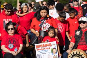 Loni Long holds a missing persons sign for her sister, Benita Long, as she stands with more than 100 people gathered for a rally to honor missing and murdered Indigenous people on Tuesday, May 5, 2026, in Tulalip, Washington. (Olivia Vanni / The Herald)