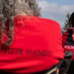 A photograph of Jolene Flores, who was a victim of domestic violence and died in 2024, is visible on a sweatshirt as people gather and listen to speakers during a rally to honor missing and murdered Indigenous people on Tuesday, May 5, 2026, in Tulalip, Washington. (Olivia Vanni / The Herald)