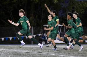 Shorecrests Kai Short and teammates run toward Shorecrests Maceo Jala after he scores the winning penalty kick to beat Edmonds-Woodway in the 3A district semifinal game on Tuesday, May 12, 2026 in Shoreline, Washington. (Olivia Vanni / The Herald)