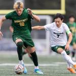 Shorecrests Cole Ambrose dribbles the ball up the field while under pressure from Edmonds-Woodways Benjamin Ikegami during the 3A district semifinal game on Tuesday, May 12, 2026 in Shoreline, Washington. (Olivia Vanni / The Herald)