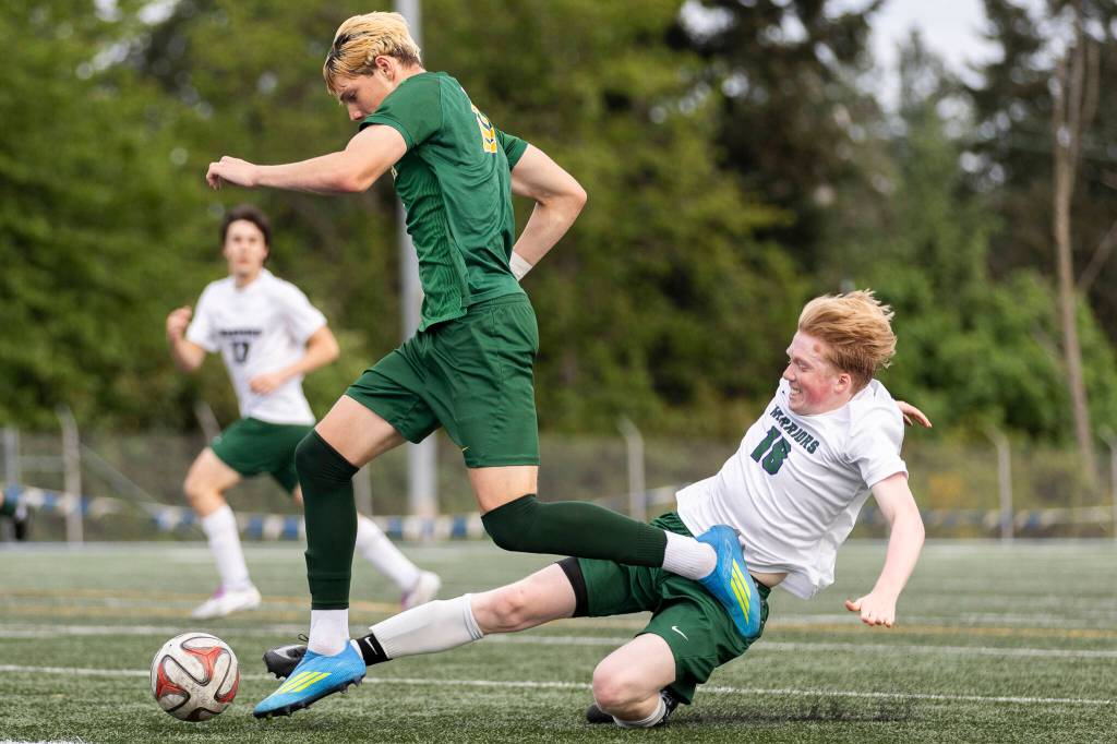 Edmonds-Woodways Jonah Sutcliffe slide tackles Shorecrests Cole Ambrose during the 3A district semifinal game on Tuesday, May 12, 2026 in Shoreline, Washington. (Olivia Vanni / The Herald)