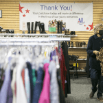 Jeanne Hoek hangs clothing on racks at the Assistance League of Everetts Thrift Store on Monday, Dec. 2, 2024 in Everett, Washington. (Olivia Vanni / The Herald)