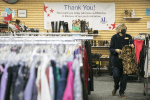 Jeanne Hoek hangs clothing on racks at the Assistance League of Everetts Thrift Store on Monday, Dec. 2, 2024 in Everett, Washington. (Olivia Vanni / The Herald)